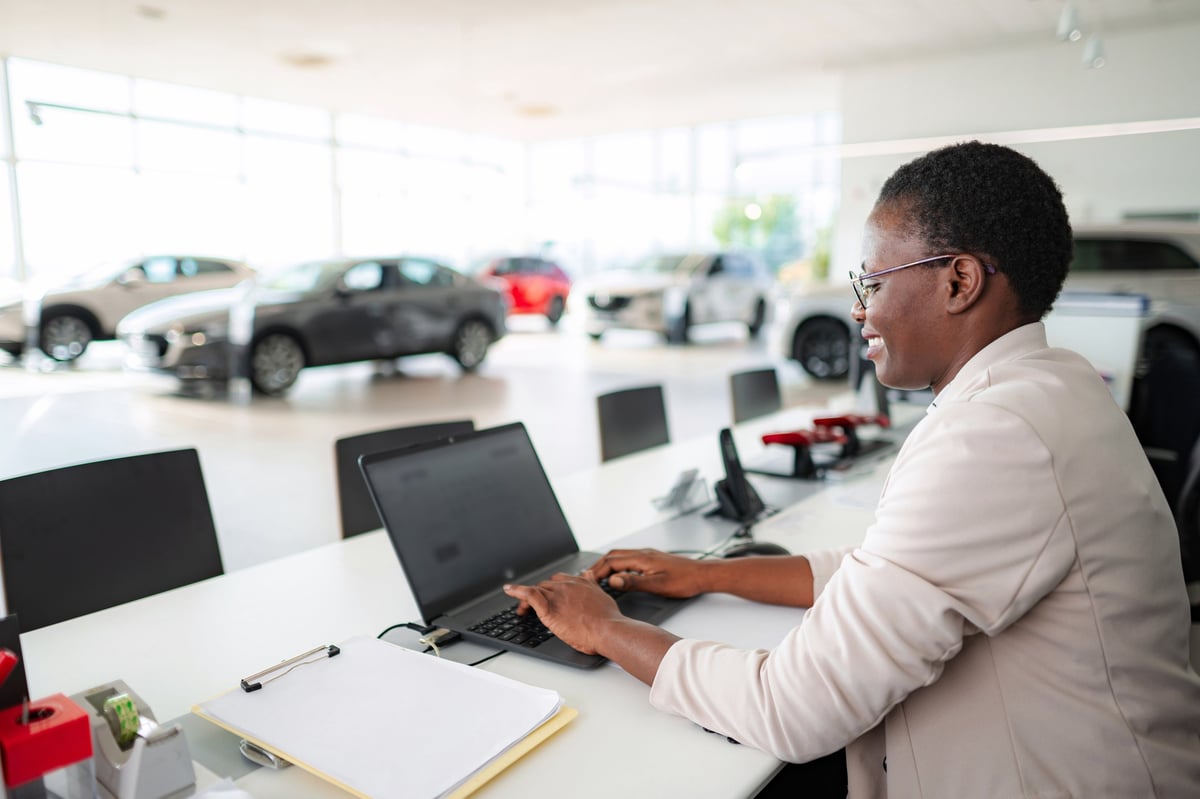 Dealership professional preparing vehicle listings on a laptop